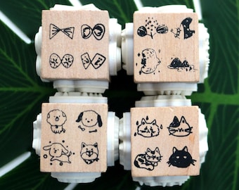 May include: Four wooden blocks with different designs. Each block has a 2x2 grid of images. The top left block has a bow, a circle, a bow, and a circle. The top right block has a fish, a plant, a bird, and a rock. The bottom left block has a dog, a dog, a dog, and a dog. The bottom right block has a cat, a cat, a cat, and a cat.