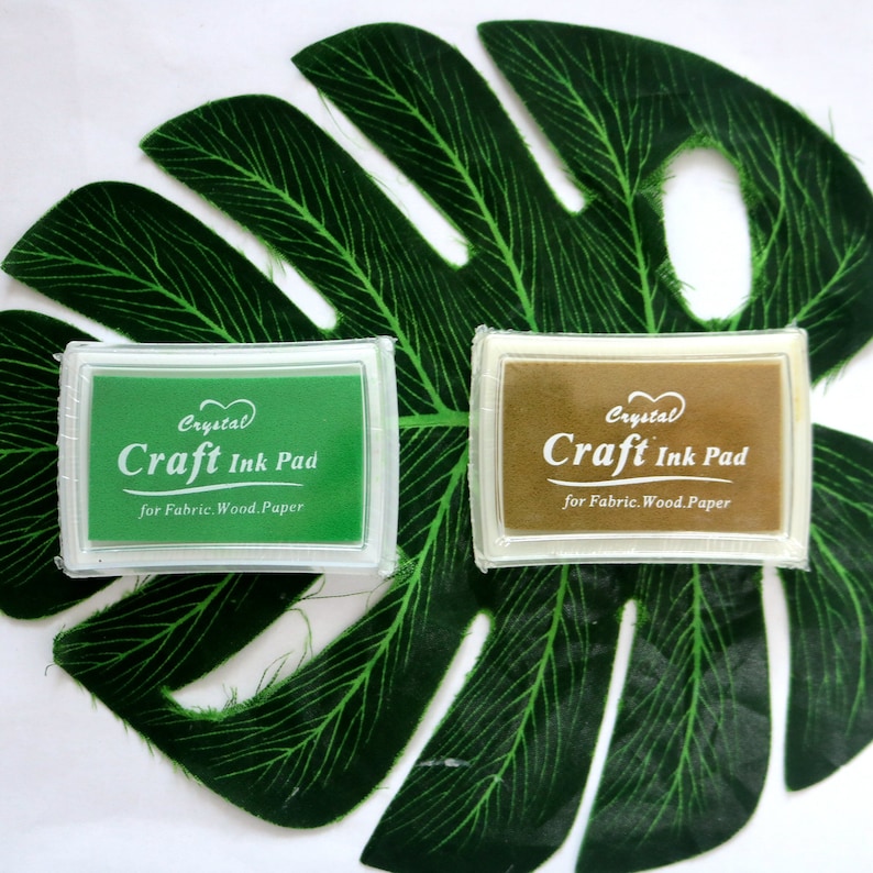 May include: Two craft ink pads, one green and one brown, with the text "Crystal Craft Ink Pad for Fabric. Wood. Paper" on each.