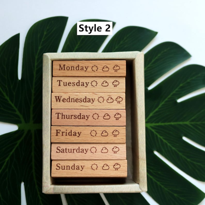 K&ouml;nnte beinhalten: Holzb&ouml;cke mit den Tagen der Woche, einem Sonnen- und Wolken-Symbol und dem Text "Style 2".