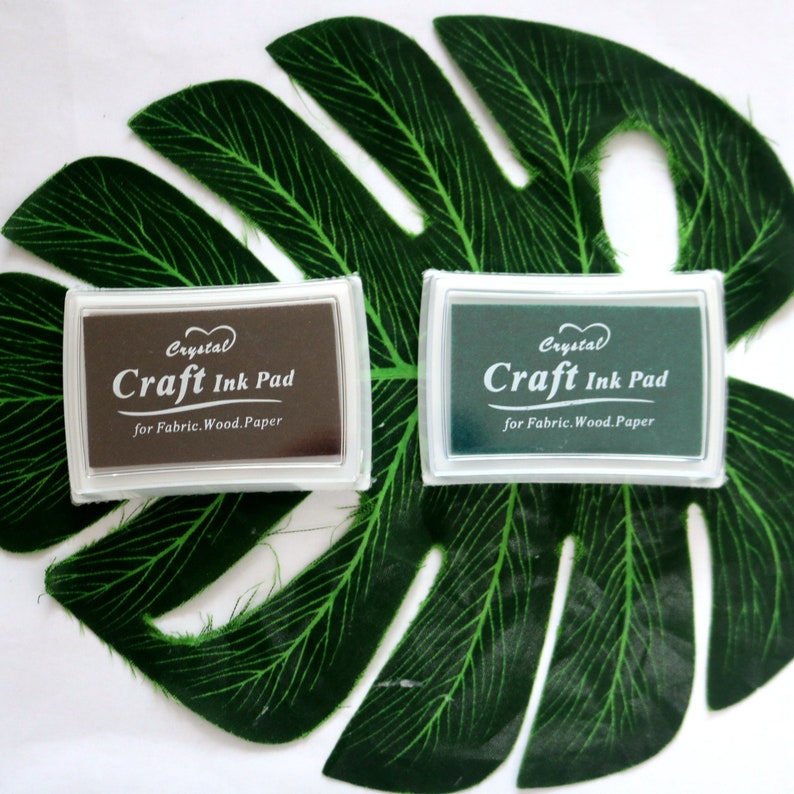 May include: Two craft ink pads, one brown and one green, with the text "Crystal Craft Ink Pad for Fabric. Wood. Paper" on each.