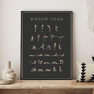 May include: A black and white poster with the text "Bikram Yoga" and illustrations of different yoga poses. The poster is framed and hanging on a wall above a wooden bench with pillows and two wooden stools.