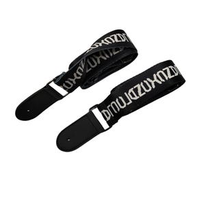 K&ouml;nnte beinhalten: Zwei schwarze Gitarrengurte mit wei&szlig;em "ZUXDZ"-Text. Sie haben schwarze Lederenden und Metallbeschl&auml;ge. Die Gurte sind nach oben links und unten rechts abgewinkelt.