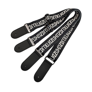 K&ouml;nnte beinhalten: Drei schwarze Gitarrengurte mit wei&szlig;em Text. Die Gurte haben schwarze Lederenden und silberfarbene Metallbeschl&auml;ge zur Einstellung. Der wei&szlig;e Text wiederholt sich &uuml;ber die gesamte L&auml;nge der Gurte.
