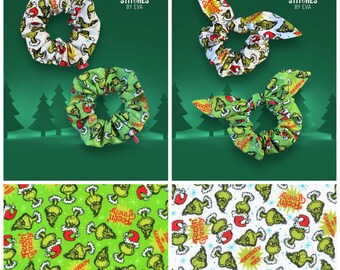 Puede incluir: Dos scrunchies con temática del Grinch, uno verde y uno blanco con detalles verdes. El scrunchie verde tiene el texto "Feelin' Grinchy" y "Naughty or Nice". El scrunchie blanco tiene el texto "Feelin' Grinchy" y "Always a little Naughty".
