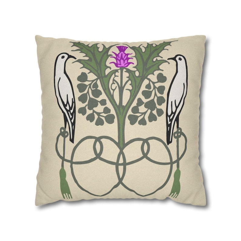 Pu&ograve; includere: Un cuscino quadrato con sfondo beige caratterizzato da una stampa grafica simmetrica. Il design include due uccelli bianchi rivolti verso l'esterno, appollaiati su elementi decorativi verdi simili a corde con nappe, che fiancheggiano un cardo viola.