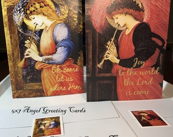 May include: Two 5x7 inch angel-themed greeting cards with gold text. One card reads "Oh come let us adore Him," the other says "Joy to the world the Lord is come." The cards are from the Wild Goose Gift Box.