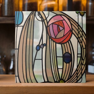 May include: Square artwork featuring a stained-glass style design. The artwork showcases a stylized rose in shades of pink and red, surrounded by flowing lines and geometric shapes in various colors. The piece is set against a light background with black outlines.