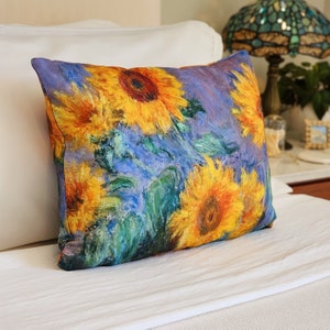 May include: A decorative throw pillow with a vibrant sunflower print. The pillow features a close-up of sunflowers in various shades of yellow, orange, and green, set against a purple background.