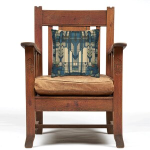 May include: A square throw cushion featuring a geometric pattern in shades of blue, cream, and brown. The design consists of intersecting vertical and horizontal lines and rectangular shapes, creating a structured, symmetrical, and repeating grid-like motif.