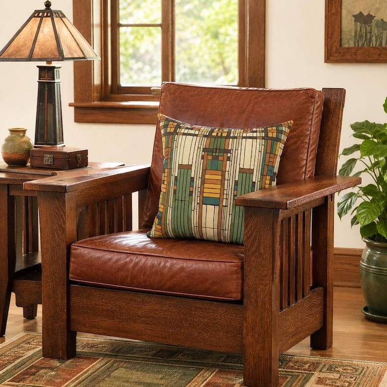 May include: A brown leather armchair with a wooden frame and vertical slat sides. A square throw pillow rests on the seat, featuring a geometric pattern in shades of green, yellow, and brown. The chair has a thick back cushion and a seat cushion.