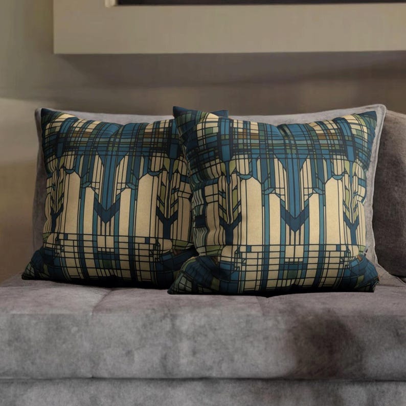 May include: Two square throw cushions featuring a geometric pattern with vertical lines and intersecting horizontal bars in shades of cream, dark blue, and muted green. The design creates a structured, architectural grid effect across the fabric.