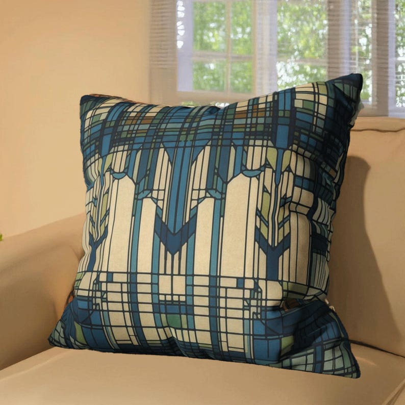 May include: A square throw cushion featuring a geometric pattern of intersecting lines and blocks in shades of navy blue, light blue, cream, and muted green. The design consists of vertical and horizontal stripes forming a grid-like structure.
