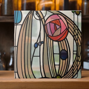 May include: Square artwork featuring a stained-glass style design. The artwork showcases a stylized rose in shades of pink and red, surrounded by flowing lines and geometric shapes in various colors. The piece is set against a light background with black outlines.