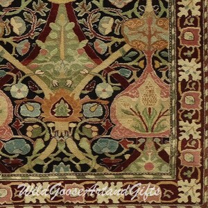 Puede incluir: Primer plano de una alfombra de color rojo oscuro, negro y crema con un patr&oacute;n floral. La alfombra tiene un borde con un patr&oacute;n repetitivo de flores y hojas blancas.