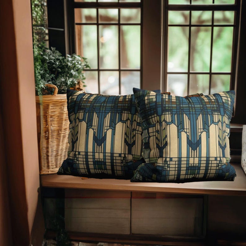 May include: Two square throw cushions featuring a geometric pattern in shades of cream, dark blue, and muted green. The design consists of vertical lines and angular shapes that create a structured, repeating motif across the fabric surface.