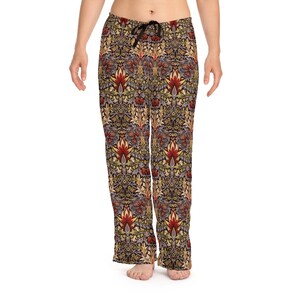Op de afbeelding: Dames pyjamabroek met een bloemenpatroon in tinten rood, geel, groen en bruin. De broek heeft een elastische tailleband met trekkoord en een ontspannen pasvorm.