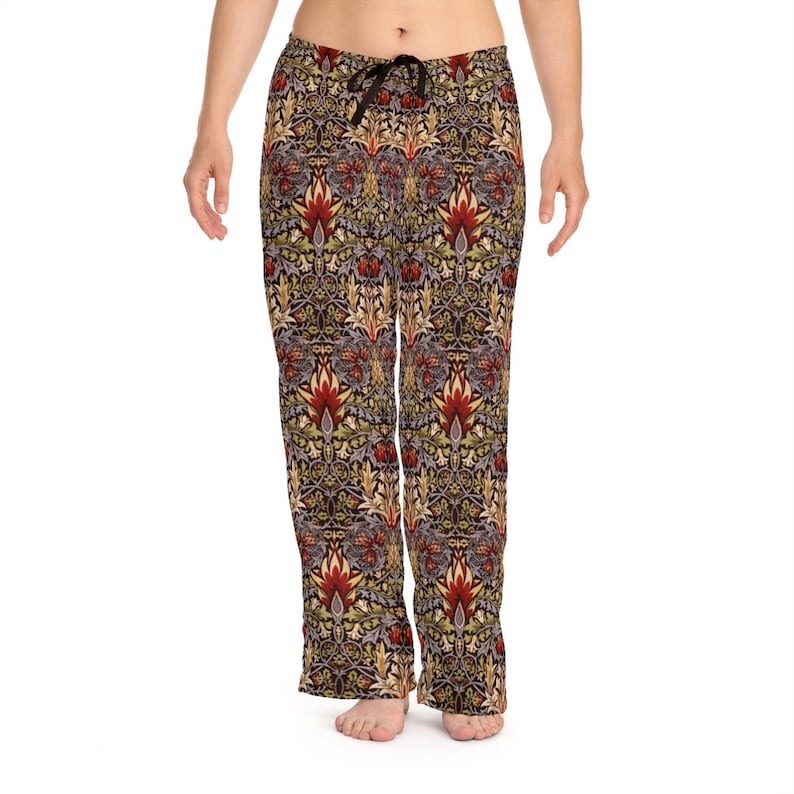 Op de afbeelding: Dames pyjamabroek met een bloemenpatroon in tinten rood, geel, groen en bruin. De broek heeft een elastische tailleband met trekkoord en een ontspannen pasvorm.