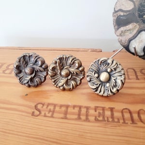 Puxadores de gaveta vintage em latão com rosetas florais, estilo Hollywood Regency.