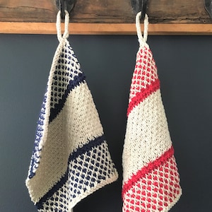 Peut inclure: Deux torchons en tricot accrochés à des crochets. Un torchon est blanc avec des rayures bleues et l'autre est blanc avec des rayures rouges.