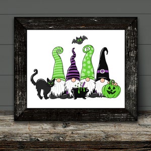 May include: A framed Halloween-themed print featuring five cartoon gnomes with green and purple hats, a black cat, a cauldron, a green pumpkin, and a bat. The gnomes have white beards and are set against a white background.