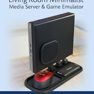 May include: Black VESA mount with a mini PC, a red and black mouse, and a black tray. The image text reads "VESA MOUNT, Living Room Minimalist, Media Server & Game Emulator". Additional text includes "MINI PC, 0 CLUTTER, VENTED FOR PERFORMANCE".