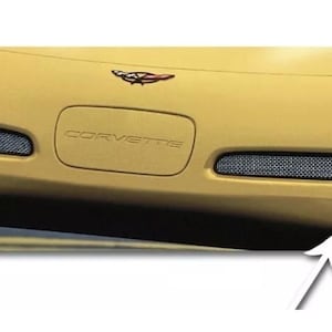 May include: A yellow Corvette sports car with a black mesh grille and the word "Corvette" embossed on the front. The car has two small vents on the front bumper.