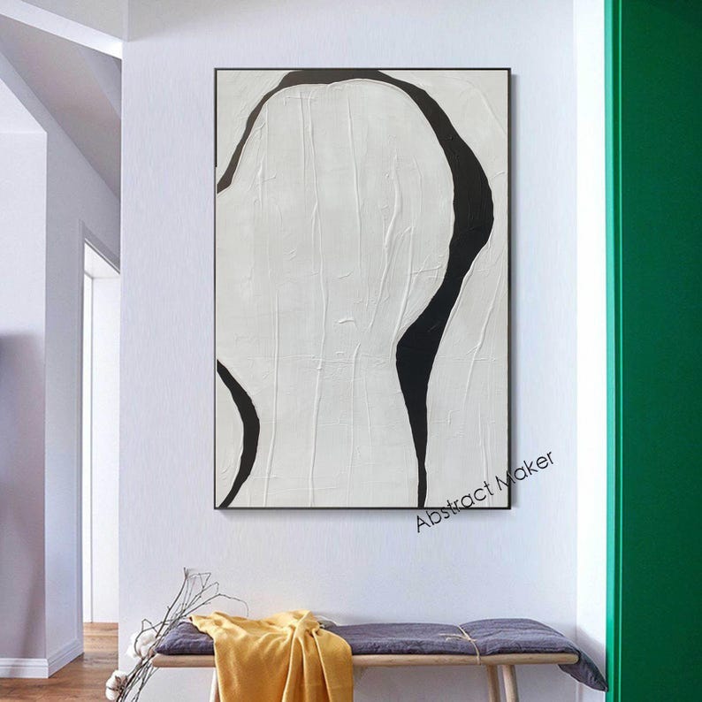 May include: Abstract art piece with a textured white background and bold black curved lines. The artwork is framed in a black rectangular frame and hangs on a white wall. The text "Abstract Maker" is visible in the lower right corner.