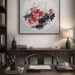 Puede incluir: Una pintura enmarcada de peon&iacute;as rojas con hojas negras y verdes sobre un fondo circular gris claro. La obra de arte cuelga sobre un escritorio de madera oscura con una silla, libros y una l&aacute;mpara. La habitaci&oacute;n tiene una est&eacute;tica tradicional y acad&eacute;mica.