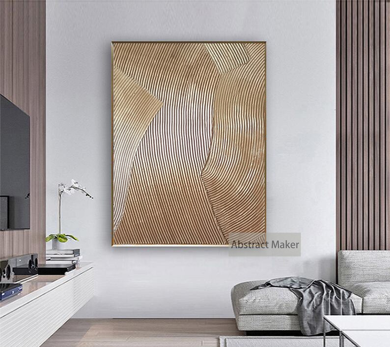 Puede incluir: Impresi&oacute;n de arte abstracto con un esquema de color dorado y blanco. La impresi&oacute;n presenta una serie de l&iacute;neas curvas que crean un patr&oacute;n ondulado. La impresi&oacute;n est&aacute; enmarcada en un marco fino dorado. "Abstract Maker" est&aacute; impreso en la esquina inferior derecha de la impresi&oacute;n.