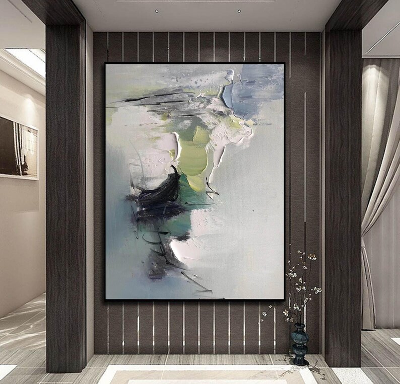 May include: Abstract painting with shades of green, blue, and white. The painting has a textured, brushstroke effect and is framed in a black frame.