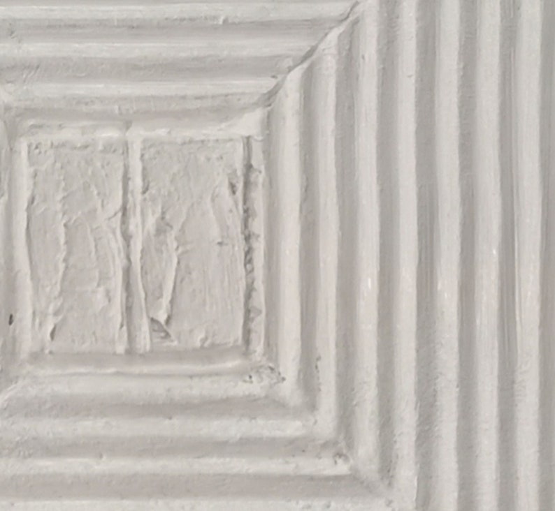 May include: A white textured square with a smaller white textured square inside. The outer square has a series of horizontal lines.