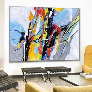 May include: Abstract painting with bold strokes of black, yellow, blue, red, and green on a white background. The painting is framed in a gray frame.