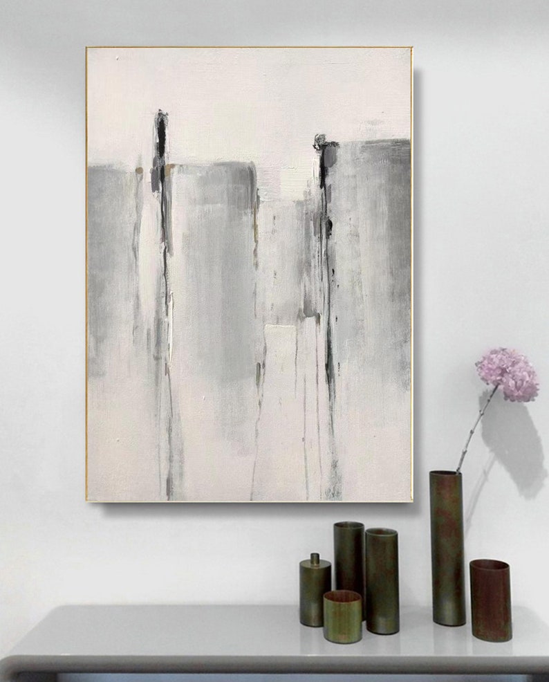 May include: Abstract painting with gray and white vertical stripes on a white background. The painting is framed in a thin gold frame.