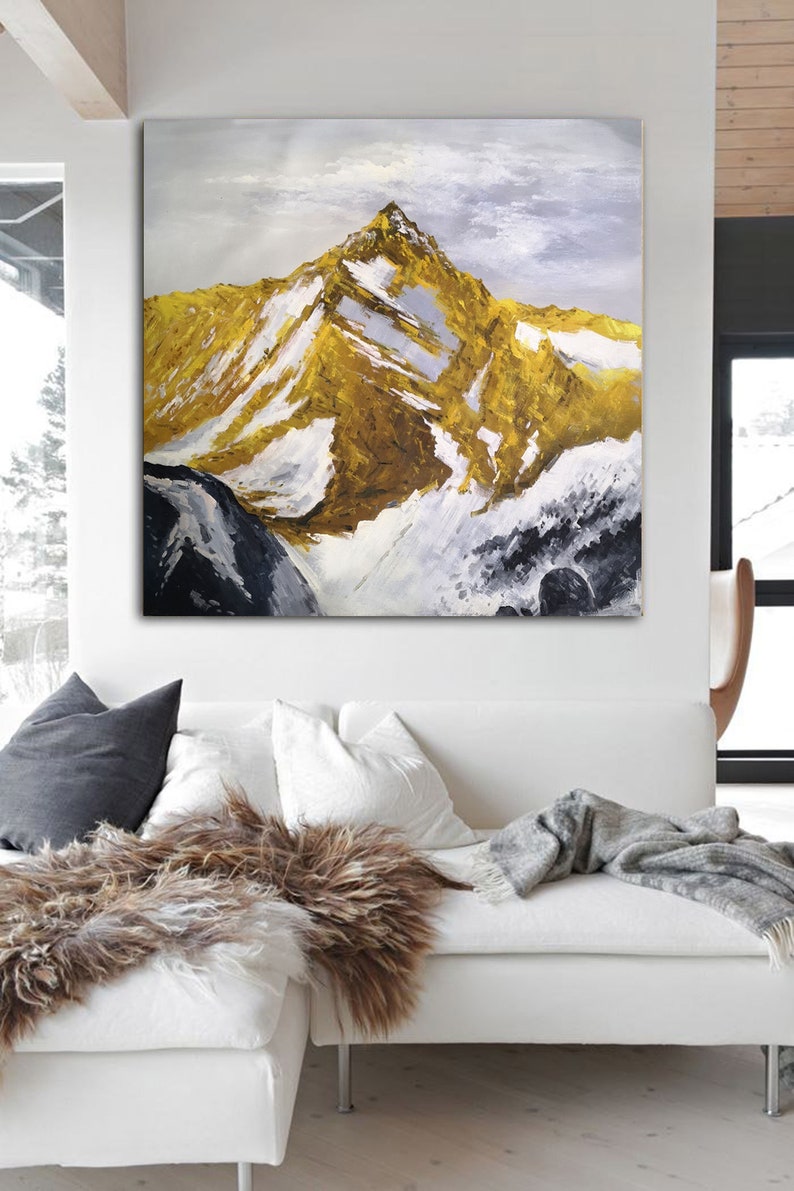 May include: A painting of a snow-capped mountain peak with a golden hue. The mountain is painted in a textured style with visible brushstrokes. The background is a light blue sky with white clouds.