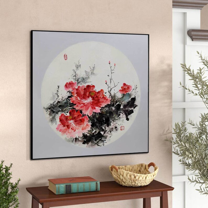 Puede incluir: Pintura enmarcada de peon&iacute;as rojas vibrantes con follaje negro y verde, sobre un fondo circular gris claro. La obra de arte es de estilo asi&aacute;tico tradicional, con un marco negro.