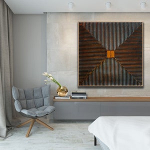 May include: A modern living room interior with a large abstract painting featuring a geometric pattern of brown and orange lines. The painting is hanging on a light gray wall above a gray sofa and a white bed.