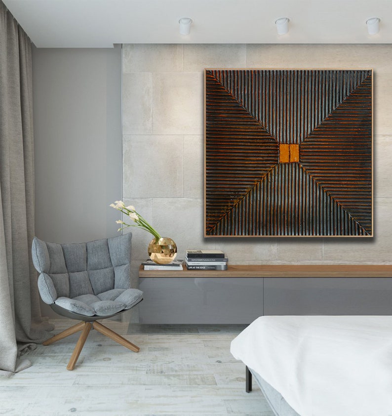May include: A modern living room interior with a large abstract painting featuring a geometric pattern of brown and orange lines. The painting is hanging on a light gray wall above a gray sofa and a white bed.