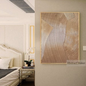Puede incluir: Impresi&oacute;n de arte abstracto con marco dorado. La impresi&oacute;n presenta un dise&ntilde;o geom&eacute;trico con l&iacute;neas curvas en tonos marrones y beige.