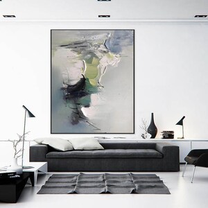 May include: A modern living room interior with a gray sofa, a black chair, and a large abstract painting on the wall. The painting features shades of gray, white, green, and black.
