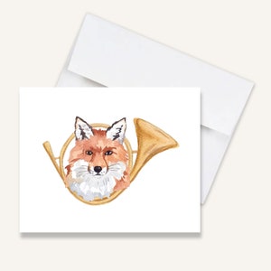 May include: A watercolor illustration of a fox's head inside a gold hunting horn. The fox has a red and orange coat with white fur around its face.