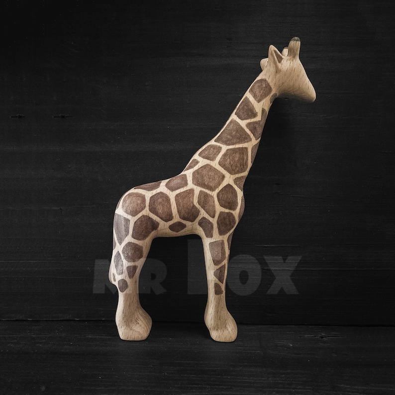 May include: A wooden giraffe figurine with a brown and tan patterned design. The giraffe is standing on a black surface.