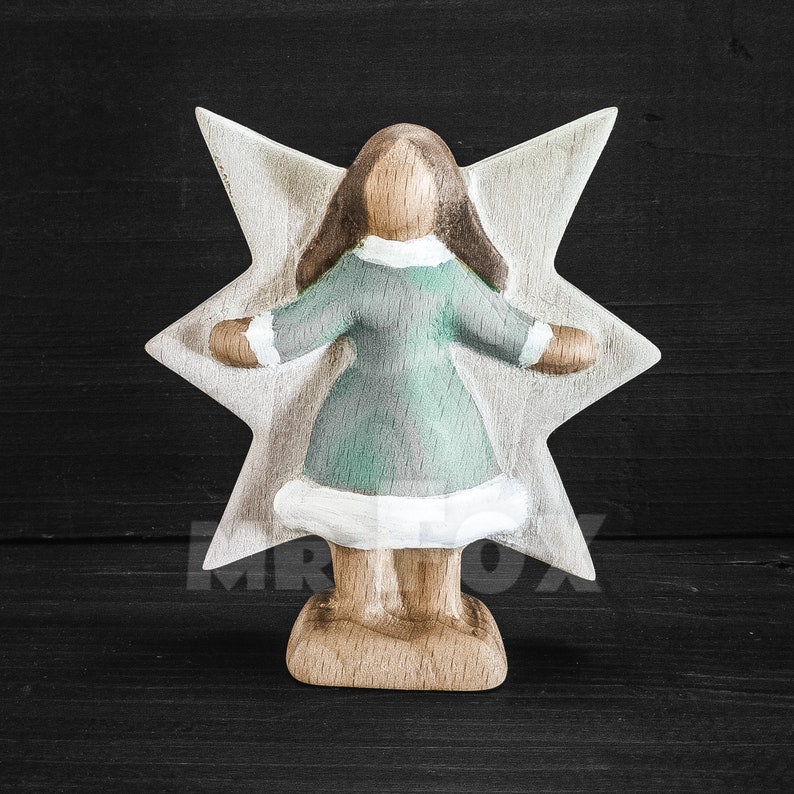 Wooden winter fairy figurine. Front view. Blue dress. White showflake shaped wings. Long dark brown hair.