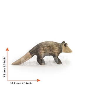 May include: Wooden anteater figurine, 4.1 inches long and 1.5 inches tall. The anteater is primarily brown with a darker, textured pattern on its back and a lighter, natural wood color on its head and tail.