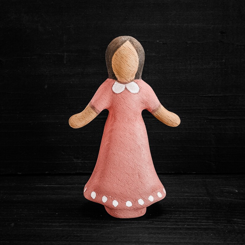 Wooden girl figurine. Pink dress.