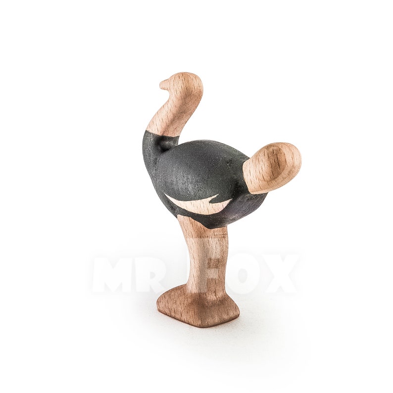 Op de afbeelding: Houten struisvogelbeeldje met een zwart-wit geverfd ontwerp. De struisvogel staat op &eacute;&eacute;n been met zijn kop naar de zijkant gedraaid.