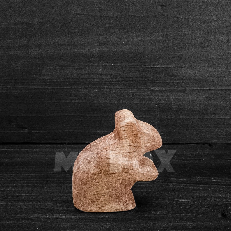 wooden field mouse against black board background side view