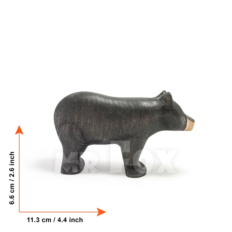 May include: A handcrafted wooden bear figurine, painted black with a natural wood snout. The bear measures 4.4 inches long and 2.6 inches tall. This decorative item is suitable for home decor or as a collectible.