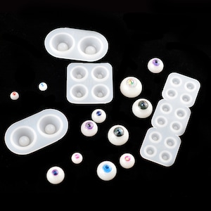 Puede incluir: Un juego de moldes de silicona para hacer ojos de mu&ntilde;eca, con una variedad de ojos de mu&ntilde;eca terminados en diferentes colores y patrones.