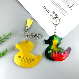 Cute duck keychain and pendant silicone resin mold for DIY gifts and jewelry making. Flexible and durable material for easy release. Use with epoxy resin, UV resin, concrete, plaster, and more. Shop now at https://findingeye.etsy.com