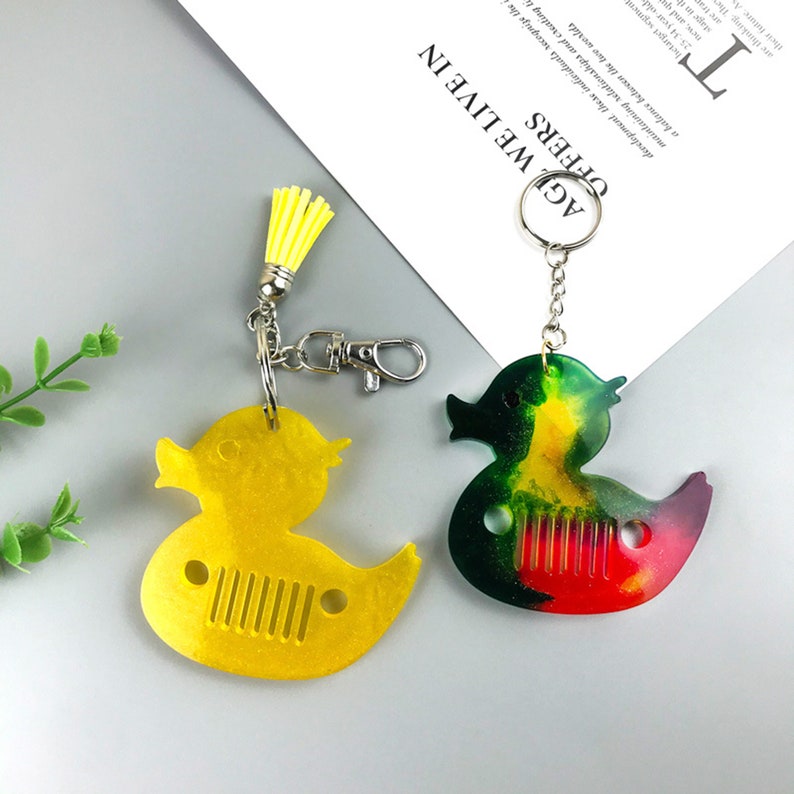 Cute duck keychain and pendant silicone resin mold for DIY gifts and jewelry making. Flexible and durable material for easy release. Use with epoxy resin, UV resin, concrete, plaster, and more. Shop now at https://findingeye.etsy.com